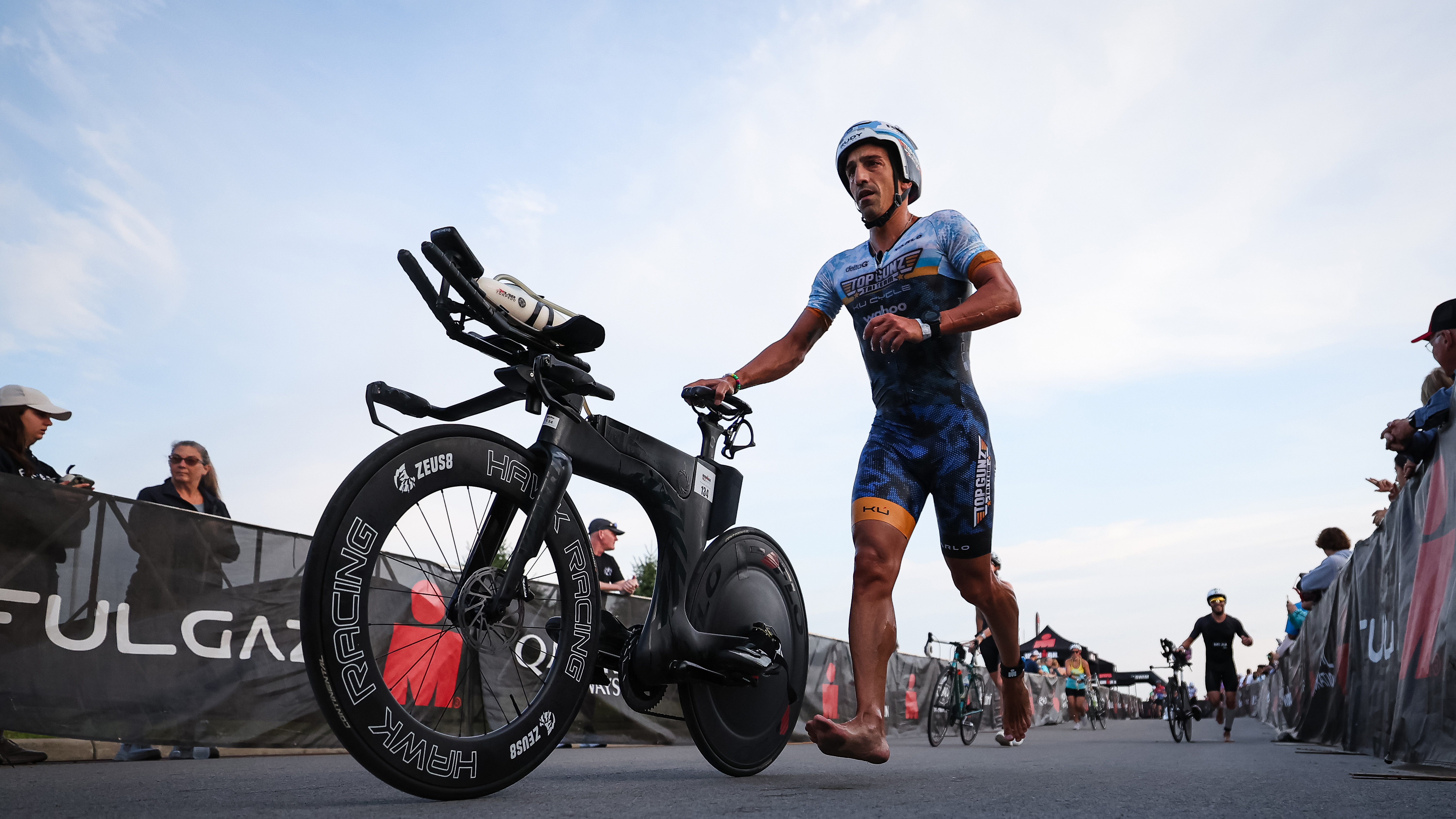 Athletes transition to the bike leg, running alongside their bikes during IRONMAN 70.3 in Ohio on July 21, 2024